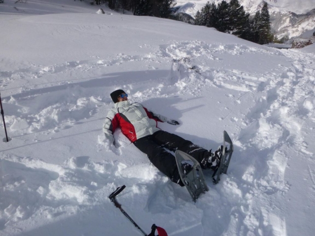  Allongé dans la neige avec des raquettes aux pieds